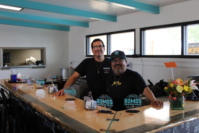 Marcus Espitia (left) and owner Mark Romo stand behind the counter at Romo's Mexican Grill, Winslow's latest culinary addition, now permanently located on the Winslow Airport tarmac. Visitors can savor their meal while enjoying the view of planes taking off and landing.