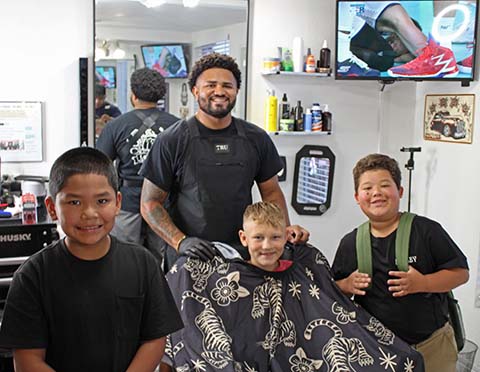 Jalen Hayes owner of FadesByJ Barbershop held his third annual free haircut and backpack drive on Sunday. Kingsley Serious (left), Jesse Solinger (middle) and Lamar Garrett (right) are excited about their polished styles right before school starts again.