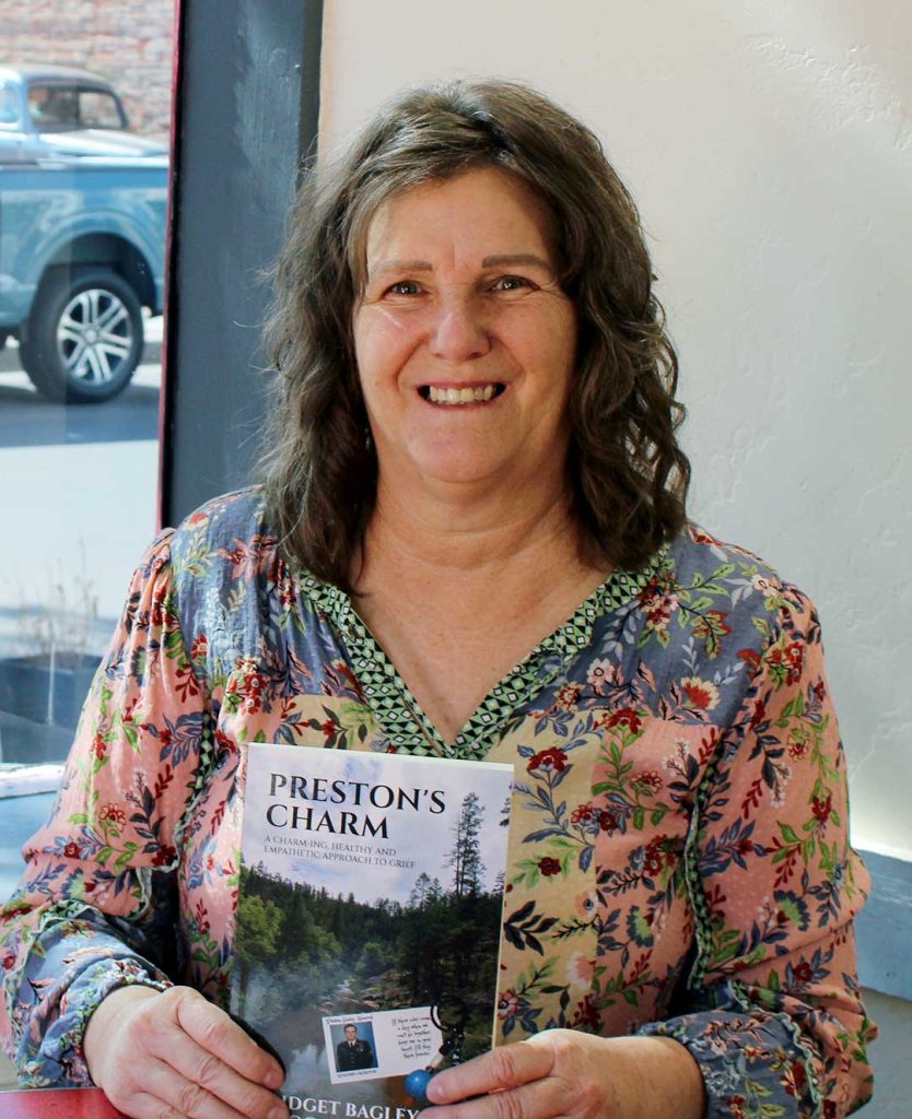 Bridgit Bagley proudly holds a copy of her newly published book, "Preston’s Charm: A Charm-ing, Healthy and Empathetic Approach to Grief," which she co-authored with Hogan Hilling.