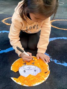 Kensie Nelson works hard making a pumpkin for her classroom bulletin board.