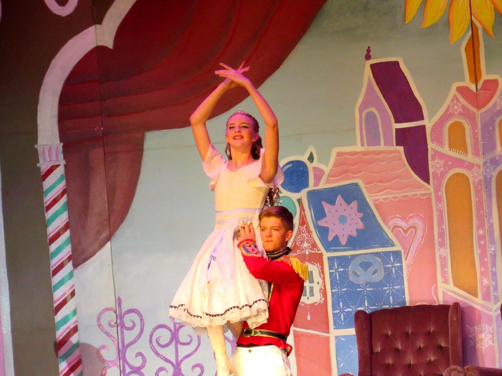The Nutcracker (Durham Reed), lifts Clara (Kamryn Wilkins) gracefully into the air.