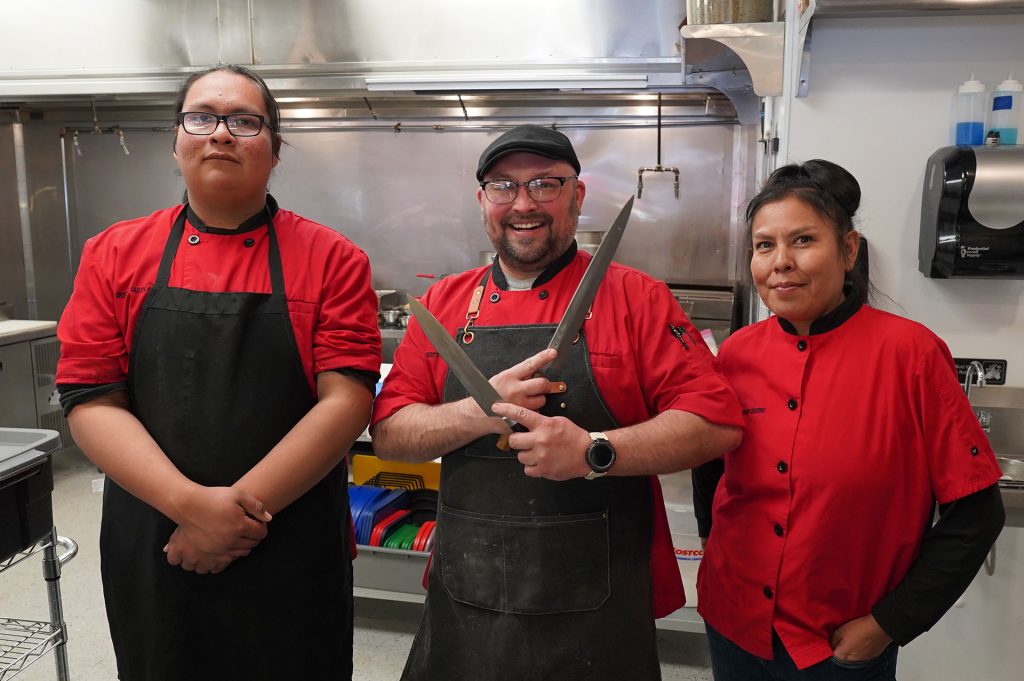 Husband and wife duo Chase (middle) and Cherise Hebert (right) standing with their son and chef Jayson (left) in the kitchen that is now their own on the corner of Williamson Avenue and Second Street. Their successful food truck has driven them to the destination of their dreams: their own restaurant.