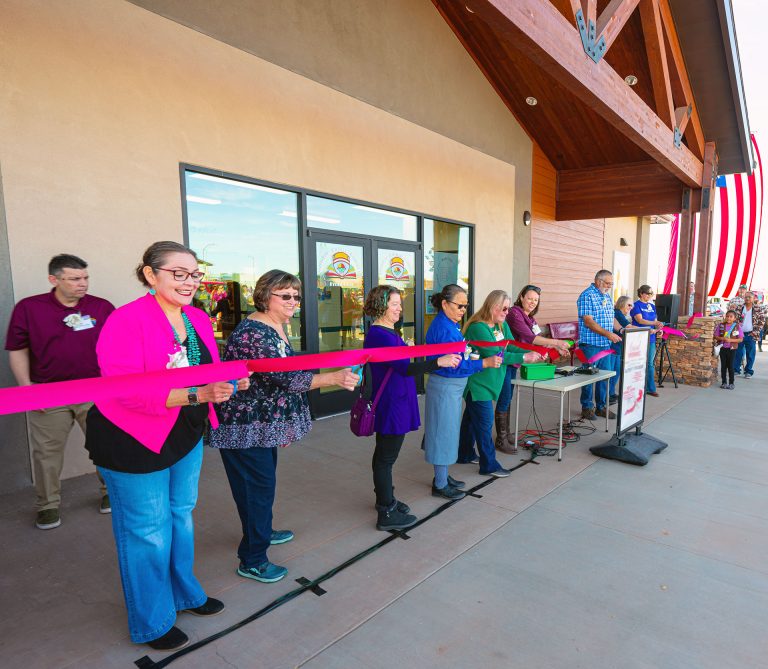 City officials and board members of the Friends of the Library lined up to cut the ribbon on the new Winslow library, which opened last Saturday. Pictured are (left to right) Mayor Birdie Cano, Lisa Maclean, Eleanore Hempsey, Fern Benally, Kathy Contreras, Brandee Leary, Ted Pate, Marianne Richardson and Kim Gould.