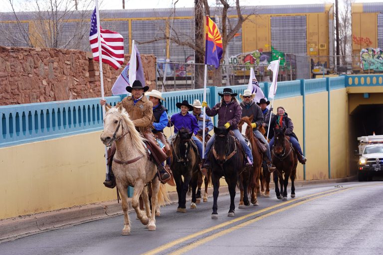 Carrying their flags, the Clear Creek Cowboys ride through the underpass on Williamson Avenue in Winslow to mark the end of their journey from Holbrook. Pictured are (left to right) Tim Kelley, Enrique Pacheco, Mica Diaz, Alejandro Pacheco, David Ramos, Jason Harris, JR Perez and Tammy Gray.