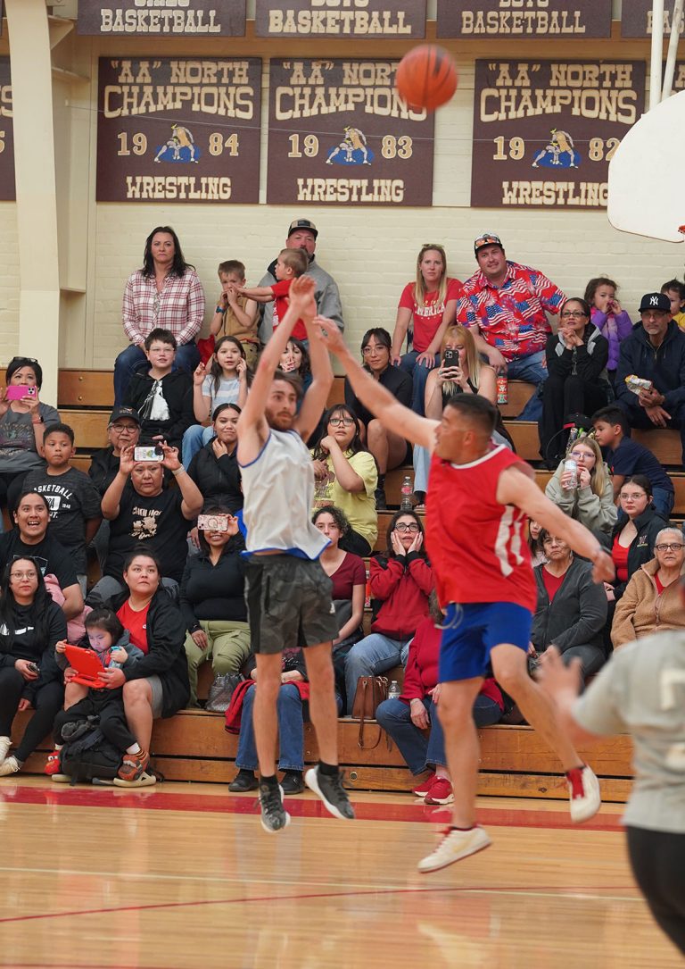 Zach Davis of the Winslow Police Department lines up a jump shot as Winslow Fire Department firefighter Sal Hernandez leaps to block him during the first annual Fire vs. Police Basketball Showdown in Winslow. In a nail-biter until the final minute, the fire department claimed a 62-57 victory in its inaugural game.