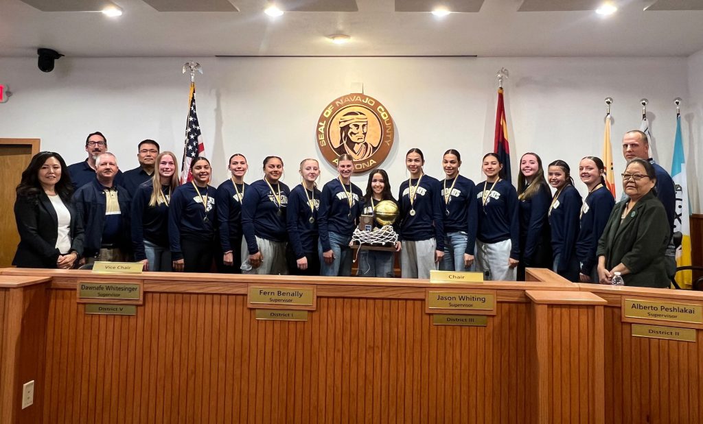 The Joseph City High School basketball team was recognized by the Board of Supervisors last week for winning the 1A state championship. Those pictured with the team and coaches include board Chairman Dawnafe Whitesinger (left), Supervisor Alberto Peshlakai (third from left) and Supervisor Fern Benally. Addressing the board during the meeting was team coach, Dan Bushman (second from left).