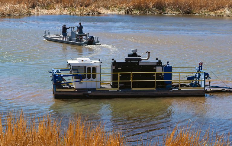 Workers head home after a long day of dredging the channel at Clear Creek in Winslow. They pump the water up the hill to the sediment ponds, which become full of water from dredging operations then the water flows over the rim of the sediment ponds back into the lake.