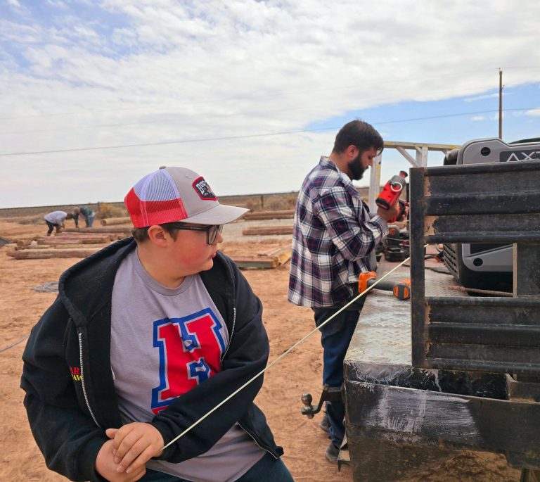 For the Jaquez family, preserving cultural icons along Route 66 is a way of life. The Jack Rabbit Trading Post was purchased in 1967 by Cindy Jaquez’ father, Glenn Blansett and is now owned by Cindy and her husband Tony. Here their son PJ Jaquez (right) and his son Stratton (left) work together along with family and volunteers to reconstruct Ella’s Frontier Trading Post (seen in the background) next to the trading post owned by their family.