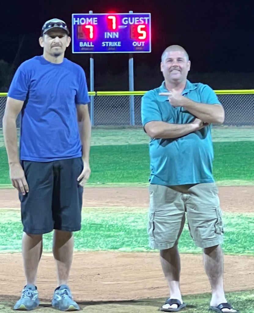 Assistant City Manager Randy Sullivan (right) gives credit to city employee Mike Young (left) for the installation of the scoreboard purchased by the Holbrook Little League board members with money specifically saved for the board at Barrow Field. Thanks to the efforts of these board members, the field now has lights and a scoreboard to give Little League players and their fans a real ballfield experience.