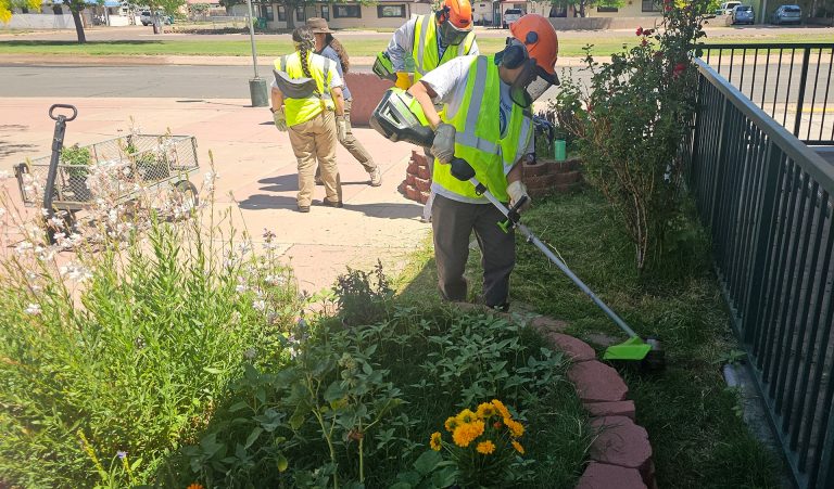 YCC youth spent the day beautifying the Holbrook Public Library by clearing out weeds and planting flowers. Chase Sherman (left) and Emery Yazzie (right) took on the task of cutting down the dense weeds and grass that grew along the library.