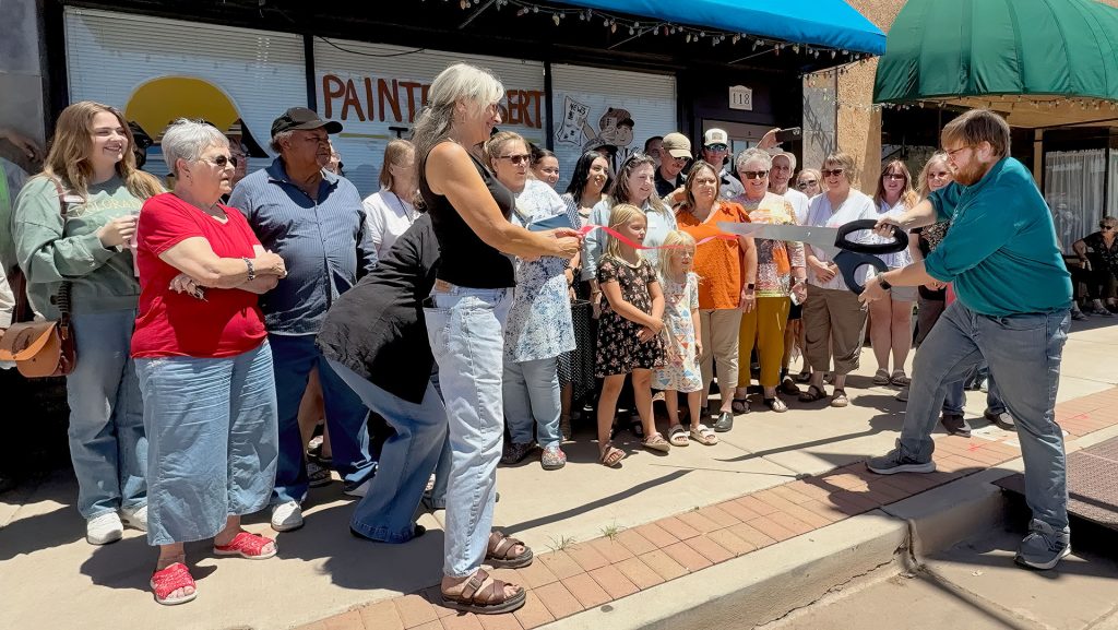 Last Thursday, the Painted Desert Tribune held a ribbon cutting at its new office at 118 E. Second St., in Winslow. Hosted by the Winslow Chamber of Commerce, the event drew an incredible turnout, with approximately 100 people from Holbrook, Winslow and across Navajo County coming to celebrate the newspaper. Pictured is the paper’s owner and publisher, Shawn White (right) as he cuts the ribbon held by Tribune Editor Linda Kor (left) and longtime KINO broadcaster Lloyd Englehardt (not picture), and a number of friends, family, elected officials and community members.