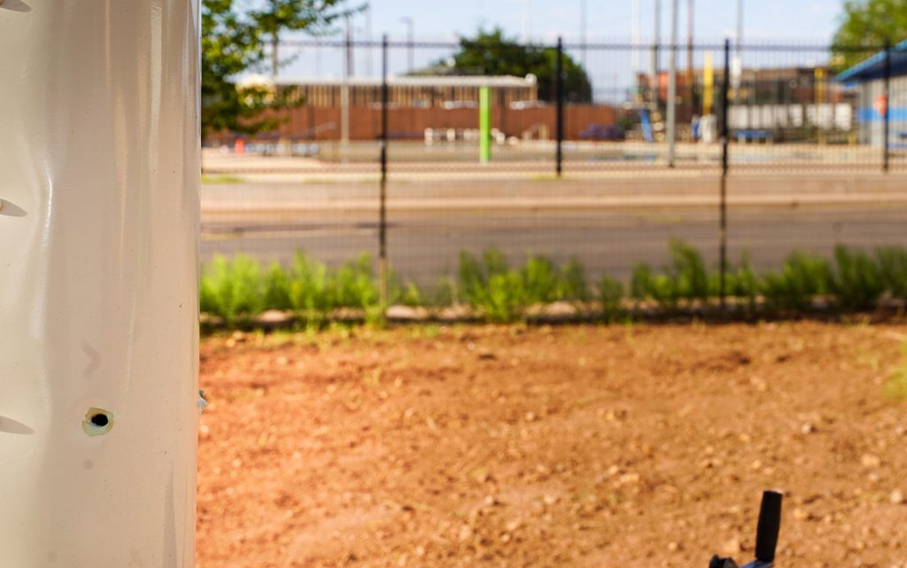 A bullet hole pierces the side of Caitlin Armijo-Martinez’s trailer, with the busy Winslow outdoor pool just beyond it, underscoring how dangerously close Saturday’s gunfire came to a crowded public space.