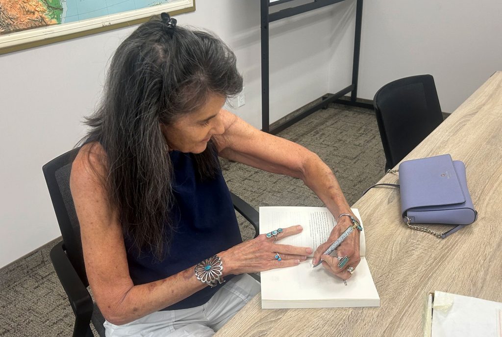 Author Lisa Schnebly Heidinger signs copies of her book “Arizona Friend Trips: Stories from the Road” during a visit at Winslow Public Library last week.