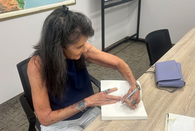 Author Lisa Schnebly Heidinger signs copies of her book “Arizona Friend Trips: Stories from the Road” during a visit at Winslow Public Library last week.