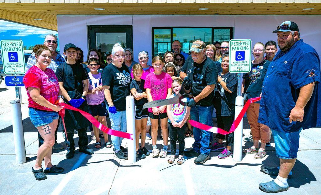 P&J’s Tasty Toppings has opened its doors in Winslow. Cortney (left), Paula (fourth from the right), Luini (holding scissors) and Martin Vargas (right) open the family run in what was the former Dairy Queen to much acclaim from attendees trying the sweet treats in the summer heat.