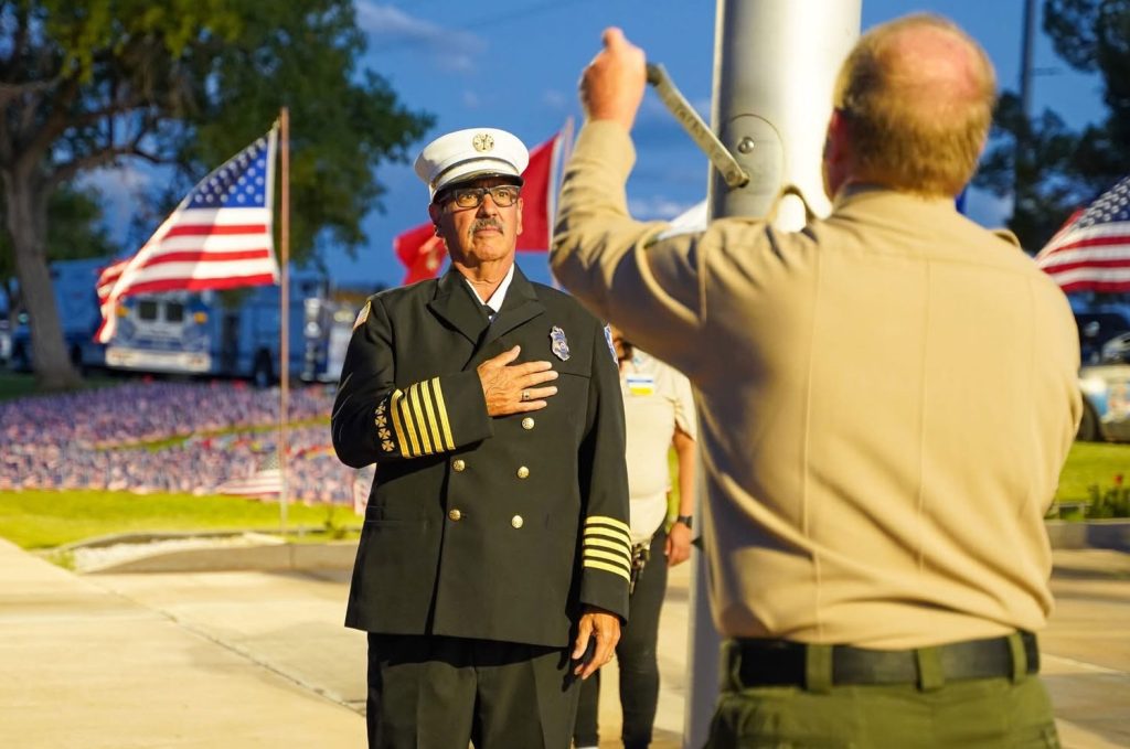 Winslow paid homage to those impacted by the 9-11 terrorist attacks at a special ceremony held at the 9-11 Memorial Park. Fire Chief Michael Duran (left) places his hand on his heart as the American flag is raised by Ken Evans (right).