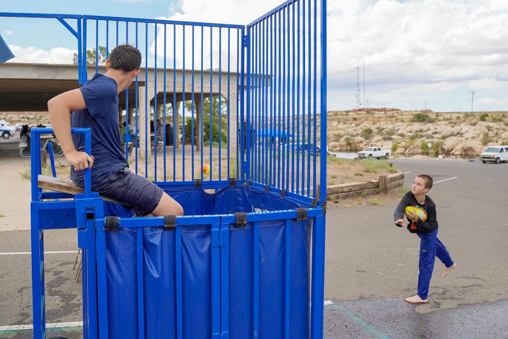 Tyler Curtis (right) throws a ball at the dunk tank target, sending Roman Bard (left) into the water during Clear Creek Days hosted by Little Colorado Medical Center at McHood Park last Saturday. The event featured kayak races, horseshoes, a rubber duck race and several local food trucks, with all proceeds benefiting the LCMC Foundation to support future events and initiatives and assist families in need.