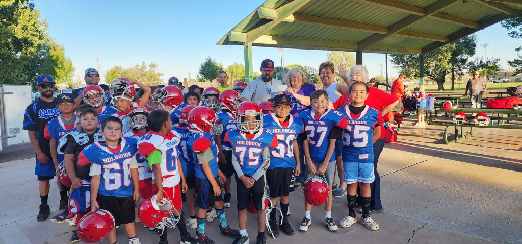 Holbrook Elks Lodge No. 2450 presented a $1,000 check to the Holbrook Youth Football and Cheer group to help with providing football uniforms for the kids. The grant was provided to Holbrook Elks from the Arizona Elks Major Projects for meeting a donation quota from local members. Pictured are Elks members Cindy Allen (holding check), Yolanda Lincoln (right of Allen), and (next to Lincoln) Beverly Goodnight, with Coach Jonathan Sample accepting the check along with players and assistant coaches.