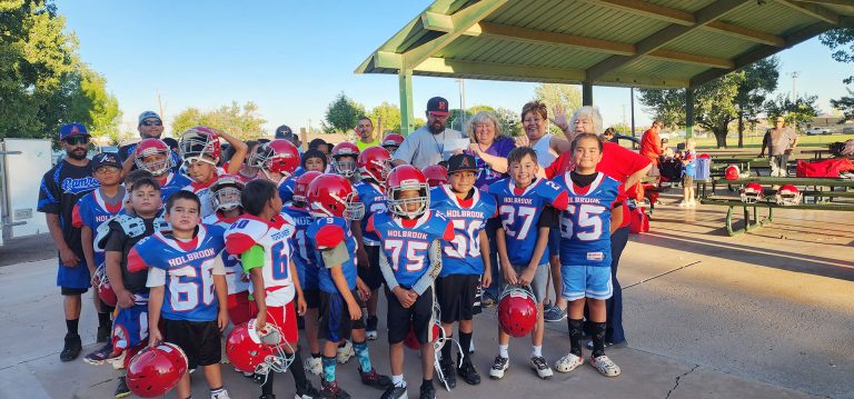 Holbrook Elks Lodge No. 2450 presented a $1,000 check to the Holbrook Youth Football and Cheer group to help with providing football uniforms for the kids. The grant was provided to Holbrook Elks from the Arizona Elks Major Projects for meeting a donation quota from local members. Pictured are Elks members Cindy Allen (holding check), Yolanda Lincoln (right of Allen), and (next to Lincoln) Beverly Goodnight, with Coach Jonathan Sample accepting the check along with players and assistant coaches.