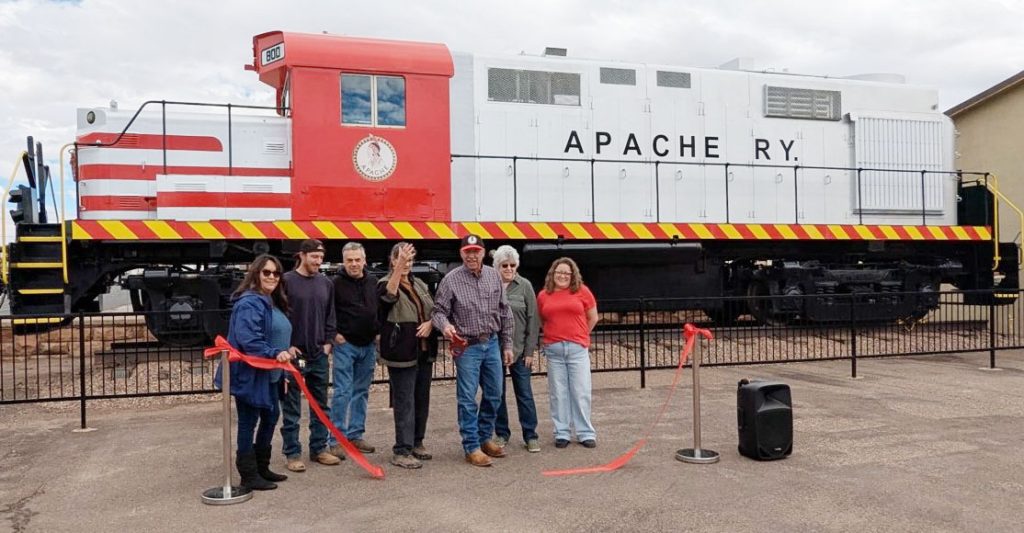 Members of the Navajo County Historical Society cut the ribbon on the Apache train car that now resides outside the historic courthouse along Navajo Blvd. in Holbrook. The organization also installed a plaque commemorating all the sponsors and volunteers who made the project possible. Pictured are (left to right) Cindy Tafoya, Christian Rudelis, Bill Parker, Sherry Reed, Aaron Colon, Lois Jeffers and Heather Griggs.
