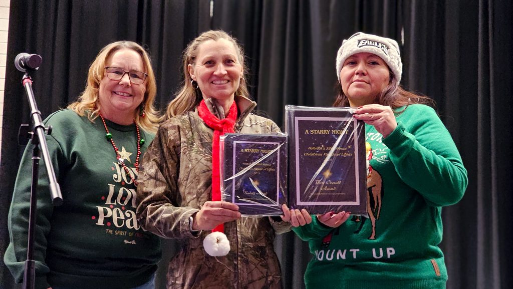 The Parade of Lights was held in Holbrook last Saturday and filled the streets with brightly lit floats, music, dancers and more. Holbrook Family Dental took not one but two prizes in the parade, the Reindeer Award and Best Overall entry. Accepting the award presented by Chamber President Janet Dean (left) and Tyreta Brown (right) was Trina Hansen (center) who along with helpers but in long hours to create the scene on display.