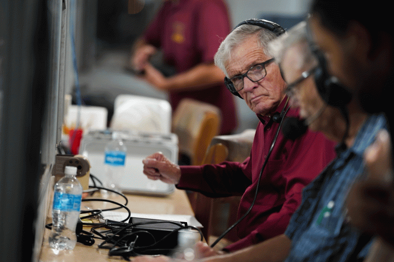 Loy Engelhardt calls a Winslow Bulldogs football game from the press box at Emil Nasser Stadium. For nearly six decades, Engelhardt's voice carried Winslow athletics into living rooms and kitchens across Navajo County.