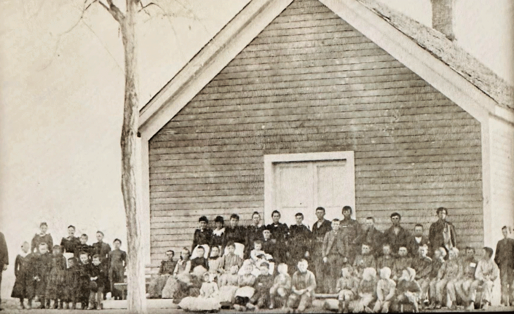 Generations of families have been raised in Joseph City since it was founded in 1876. This is the first public building in community built in 1887-88, which served as both an LDS church and a school. This photo shows school children circa 1893. The building was used as a school until 1916, then a brick church building was built between 1903 and 1909.