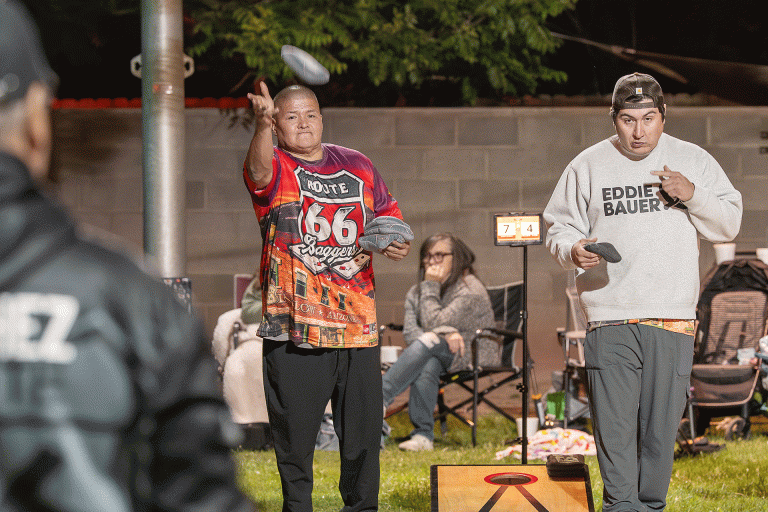 Terry Katoney (left) tosses a bean bag Saturday during a cornhole tournament at Standin’ on the Corner Park in Winslow, while opponent Paul Mazon (right) waits his turn. The event was one of the first city-sponsored events tied to Winslow’s Route 66 centennial celebration and was also sponsored by the Route 66 Baggers, a local cornhole group that meets twice a month for tournaments.