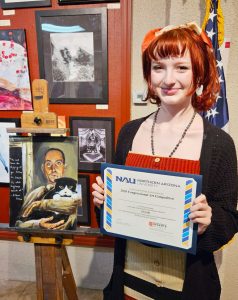 Lindsay Cox stands with her first-place artwork and $9,000 Northern Arizona University scholarship award after being named the winner of the 2026 Congressional Art Competition for Arizona’s Second Congressional District during an awards ceremony at the Phippen Museum in Prescott Valley.