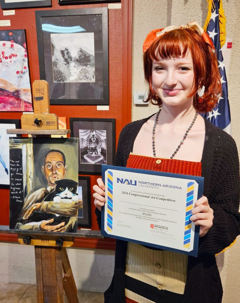 Lindsay Cox stands with her first-place artwork and $9,000 Northern Arizona University scholarship award after being named the winner of the 2026 Congressional Art Competition for Arizona’s Second Congressional District during an awards ceremony at the Phippen Museum in Prescott Valley.