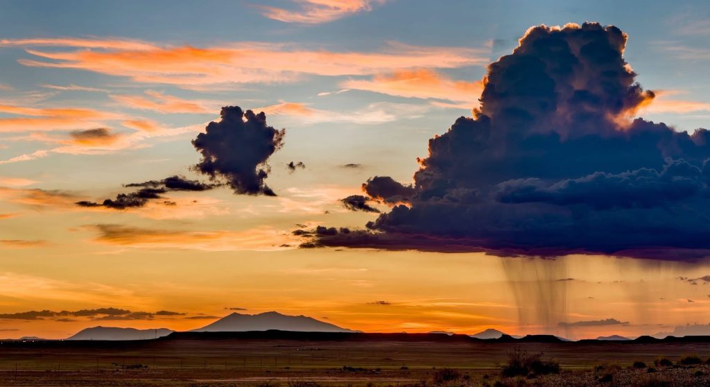 A summer sunset brings a warm glow to the evening sky over northeastern Arizona, offering a quiet moment amid the changing monsoon weather.
