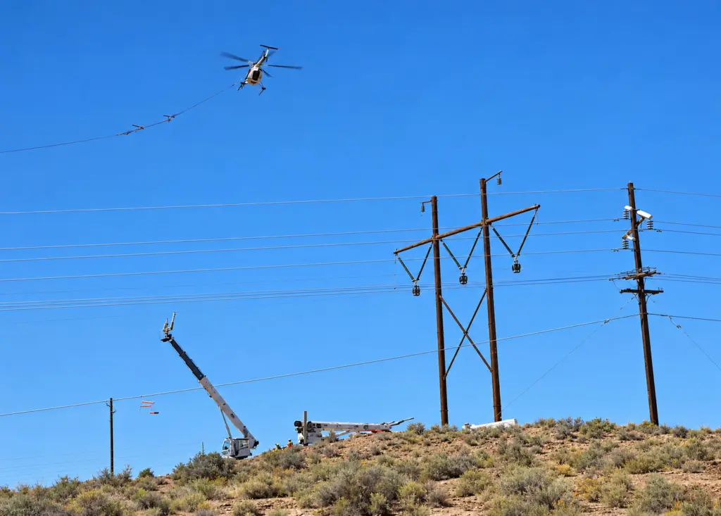 Photo by Talaina Kor Last week crews used a helicopter to add electrical transmission lines to the existing power grid at Cholla Power Plant along I-40 between Joseph City and Holbrook. Solar and wind projects require new transmission infrastructure or upgrades to existing lines so electricity can be delivered to the grid.