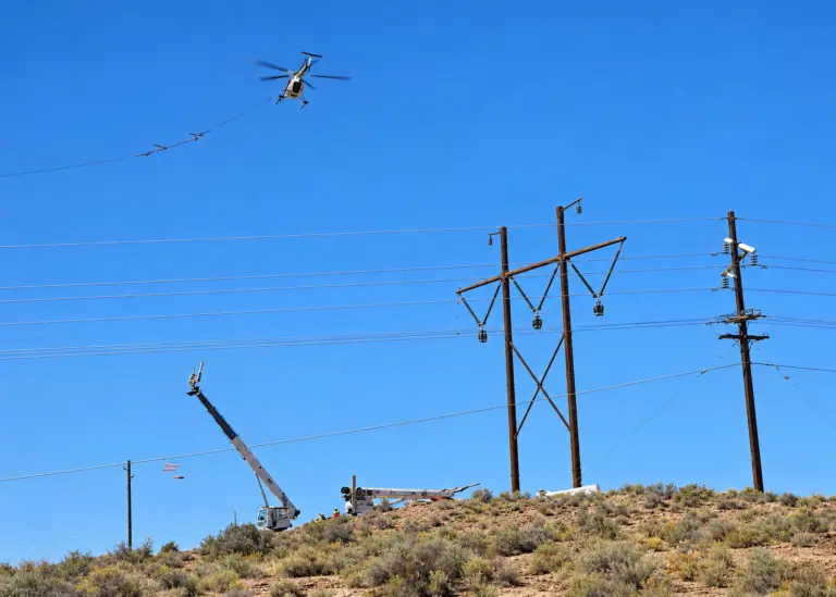 Photo by Talaina Kor Last week crews used a helicopter to add electrical transmission lines to the existing power grid at Cholla Power Plant along I-40 between Joseph City and Holbrook. Solar and wind projects require new transmission infrastructure or upgrades to existing lines so electricity can be delivered to the grid.