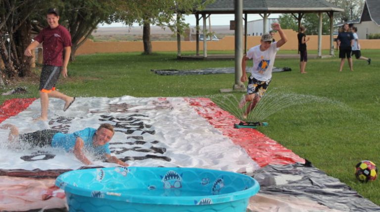 Photo by Linda KorAaron Johnstun slides into home plate after an effort by Jason Gardner (left) to tag him out as Cameron Baldwin (right) closes in on him during a game of slip n’ slide kick ball at Tanner Park in Joseph City July 20. The game, organized by the Midway Ward, brought about 30 youth out for one last celebration of summer prior to the Aug. 15 start of school for students in the Joseph City School District.