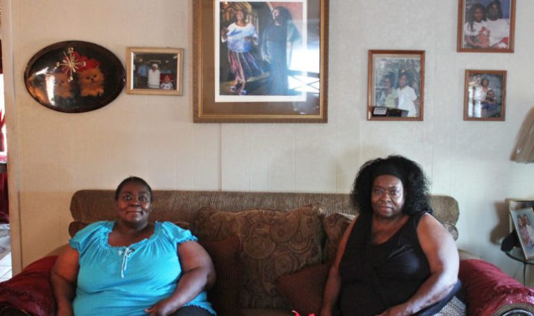 Photo by Talaina FisherSisters Brenda (left) and Mary Alice Hayes sit in front of a reproduction of the painting created by artist Tina Mion depicting them as they perform. The original hangs in a museum at the Smithsonian Institution in Washington, D.C.