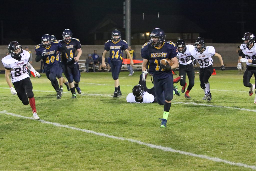 Photo by Kellie Spangler/spanglerpics.com - Joseph City Wildcats took down the Mustangs last Saturday in the first round of playoffs. Here No. 22 Troy Poudrier runs for a touchdown, adding to the final score with the assistance of No. 40 Rance Haddox, No. 66 Ben Spurlock and No. 24 Kaden Westover.