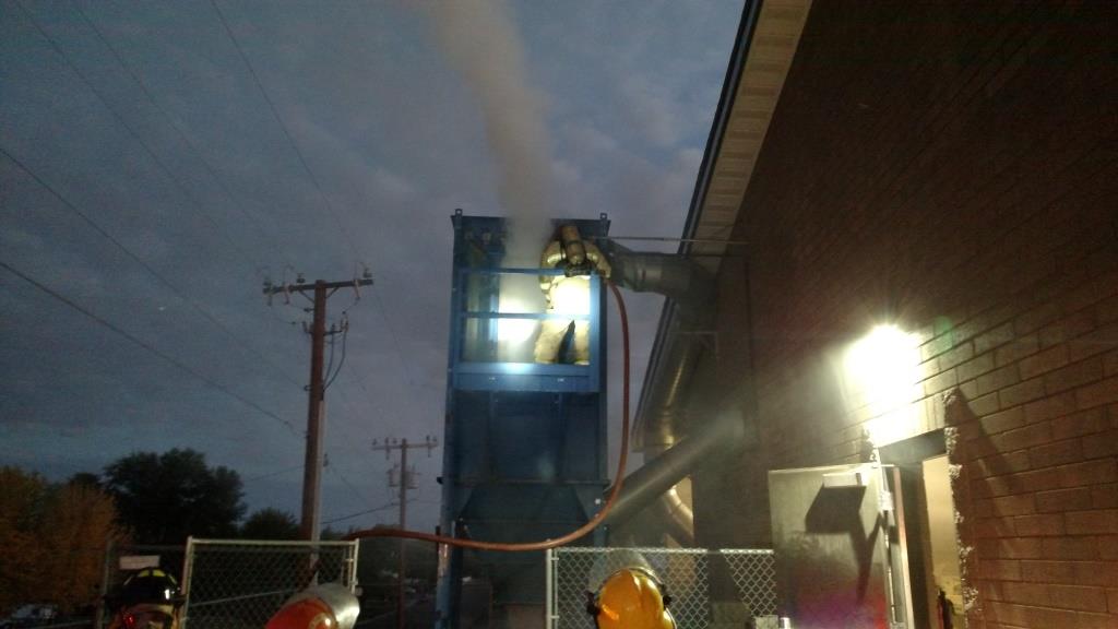 Photo courtesy of the Taylor-Snowflake Fire & Medical Department - Two arson fires were set at Snowflake High School early last week, including this one at the woodshop hopper being fought by a fireman from the Taylor-Snowflake Fire & Medical Department.