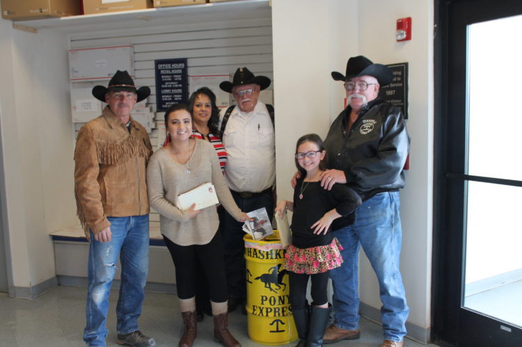 Photo by Linda Kor - The 59th annual Hashknife Posse Pony Express ride will begin on Wednesday, Feb. 8, and the riders have already begun collecting the mail for the more than 200-mile trek from Holbrook to Scottsdale via horseback. Special Pony Express mailers are available for $1, and barrels are placed at post offices in Holbrook, Winslow, Joseph City and Snowflake. Mariah Kelley (second from left) and Ella Palffy (second from right) make the ceremonial first letter drop in the barrel at the Holbrook Post Office as (left to right) posse member Tim Kelley, Holbrook Postmaster Loretta Short, and posse members Jim Mobley and Bill Perkins look on.