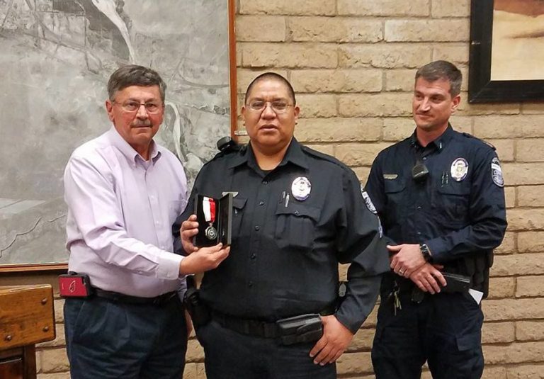 Photo by Steve PaukenWinslow Police Corporal Lawrence Dashee (center) was awarded a medal for bravery and service after he saved a local family from a residential fire in the early morning hours of Sept. 14, 2016. Presenting the award at the Winslow City Council meeting last week were Director of Police Services Chris Vasquez (left) and Lt. Ken Arend (right).