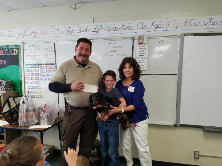 Courtesy photoHolbrook Animal Control Officer Merrill Young receives a check from Davey Beltran and Twyla Taylor for use at the animal shelter. The check represented half of a reward Davey received from Twyla and Rick Taylor for finding their dog Romo (in Davey’s arms).