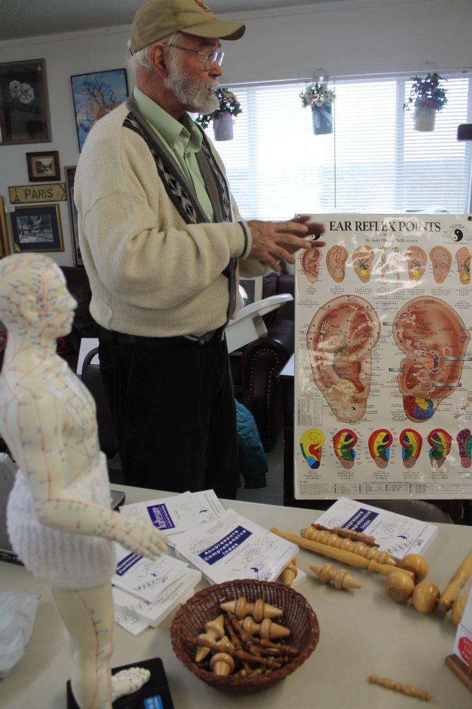 Photo by Chanae NielsonMonte Cunningham, pictured with his books, tools and diagrams, gives advice for relieving pain using techniques he developed.