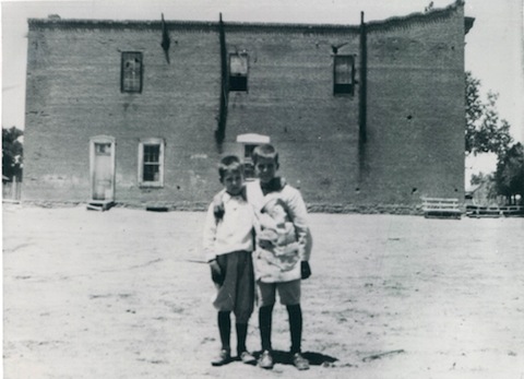 Photo courtesy of the Navjao County Historical SocietyThe Arizona Cooperative Mercantile Institution (ACMI) only stayed in Woodruff for about six years. When the railroad came in August 1888, the store was moved to Holbrook and the empty building was purchased by the town of Woodruff. The two boys pictured in this undated photo in front of the empty building are Leo Gardner and Ross Brinkerhoff.