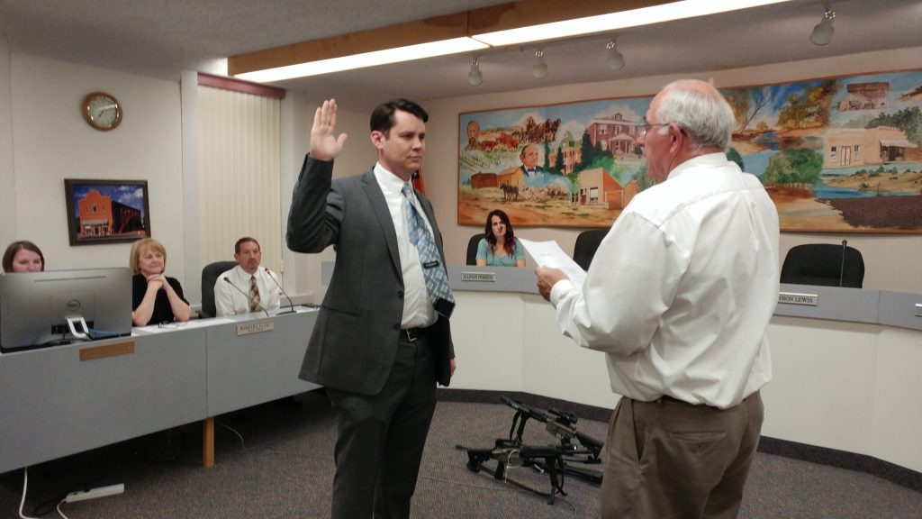 Photo by Naomi HatchJudge Fred Peterson (right) administers the oath of office to Hunter Lewis (left) to serve on the Snowflake Town Council at the March 21 council meeting.