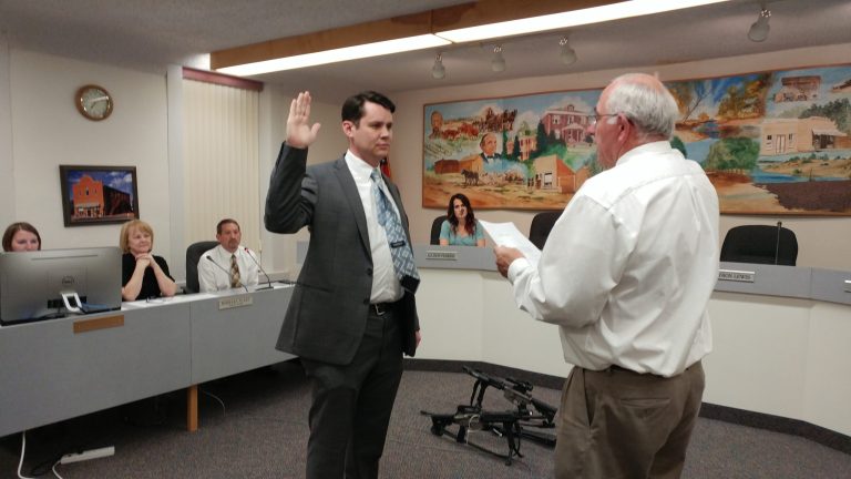 Photo by Naomi HatchJudge Fred Peterson (right) administers the oath of office to Hunter Lewis (left) to serve on the Snowflake Town Council at the March 21 council meeting.