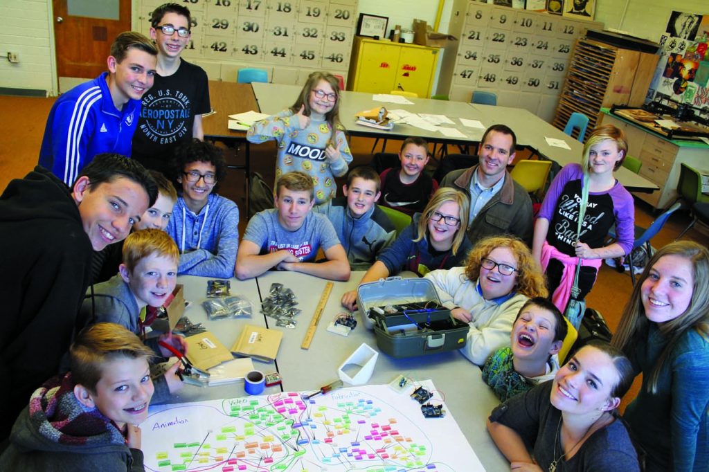Photo by Chanae NielsonSnowflake Junior High School students (left to right) Daylen Webb, Kaika Burk, Jacob Martineau, Carson Bassett, Dylan Neff, Caleb Decker, Logan Baird, Ryan Borota, Myah Harris, Kimball Goodman, Caleb Gurr, Jenna Hagelstein, teacher Mike Eilertsen, Page Holfeltz, Lori McCain, Preston Charlton, Anna Berger and Corynn Cottrell are working on the prototype of their entry in the Samsung Solve For Tomorrow competition, a wildlife detection system designed to reduce crashes in rural areas.