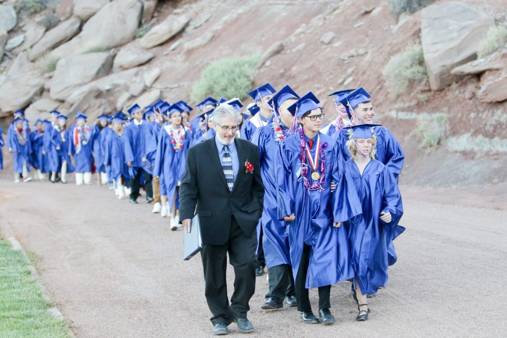 Photo by SpanglerpicsHolbrook High School Principal Lance Phaturos walks the Class of 2017 into Roadrunner Stadium with seniors (left to right) Eddie Gibson, Hope Bowden and Robert Romo leading the way.