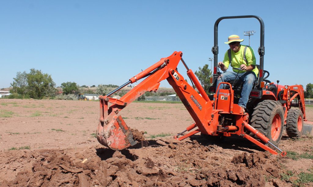 Photo by Linda KorCity Manager Randy Sullivan spent some time Monday morning digging a sprinkler system trench for an expansion of the soccer field for kids at Hunt Park in Holbrook. The land on the west side of the swimming pool has been cleared and the trees piled in the background were removed from along the fence line. It is expected that the expanded field will be ready for use in two years, making it regulation size so that tournaments can be held there and on the field being developed at nearby Park Elementary School.