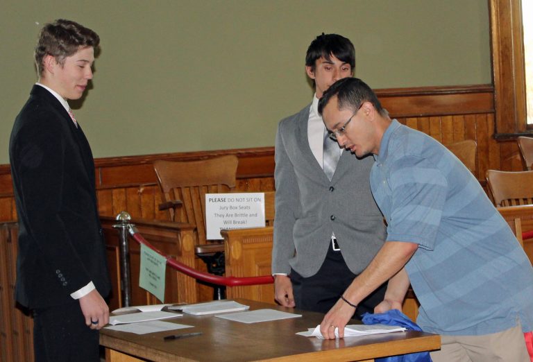 Photo by Toni Gibbons Holbrook High School teacher Nick Moyte (right) gives final instructions to students Harrison Edwards (left) and Jack Hardy II (center) during teen court held at the historic Navajo County Courthouse.