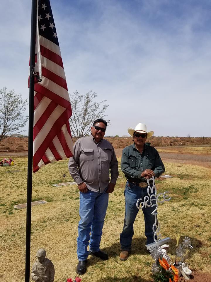 Photo by Lawrence Kenna Larry Begay (left) and Layman Brown (right) stand next to one of the flags that they planted as part of a project to ensure that all veterans at Desert View Cemetery receive recognitions for their service.