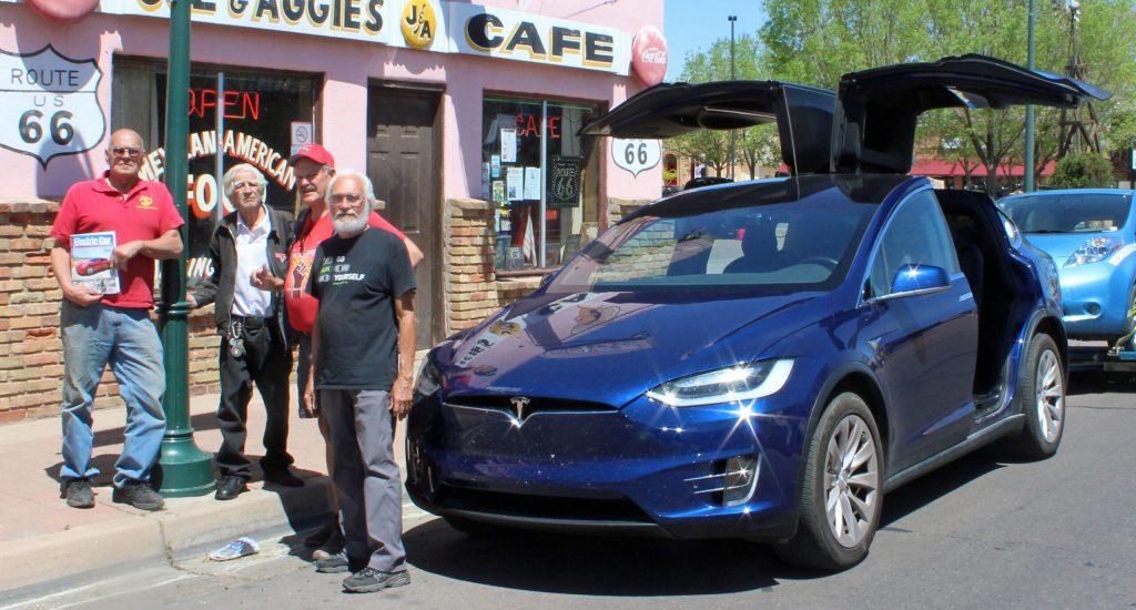 Photo by Toni GibbonsTEVA representatives David Gebert (right) and Jerry Asher (second from right) take a lunch break at Joe and Aggie’s Café on April 26. The 2017 Tesla Model X Electric Vehicle is pulling the classic 2011 Nissan Leading Economical Affordable Family car known as the Spirit of AZ. Also pictured are (left to right) Holbrook City Councilman Earl Kester, and Stanley Gallegos, owner of Joe and Aggie’s Café.